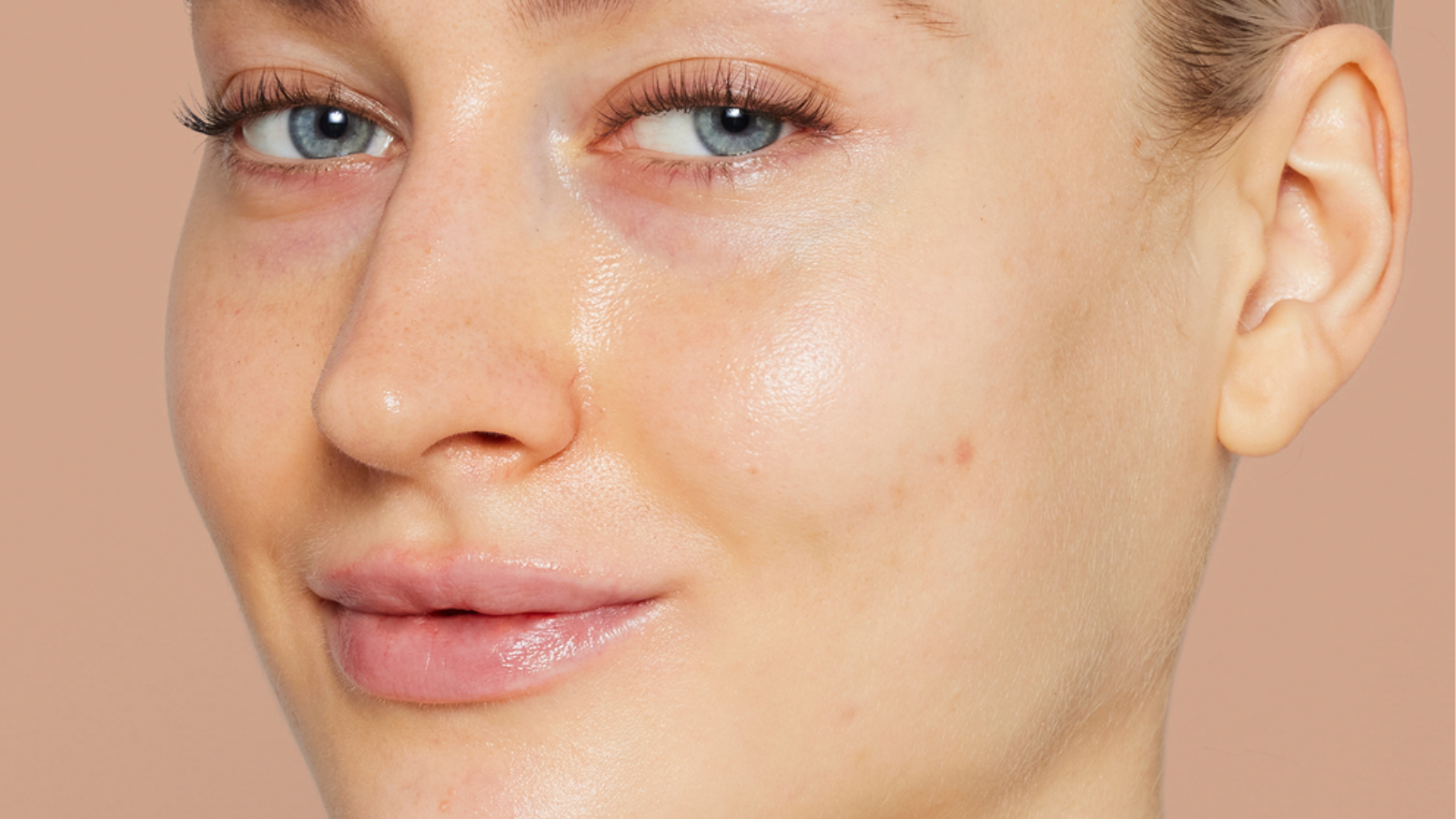 Krupni plan lica modela sa vidljivim crvenilom, manjim nesavršenostima i mat kožom, koji prikazuje stanje kože prije nanošenja Jane Iredale Skintuition proizvoda.